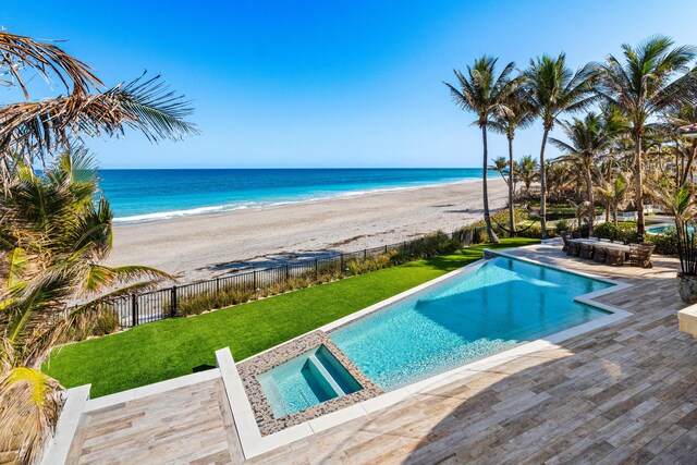 view of pool featuring an in ground hot tub, a water view, fence, and a fenced in pool