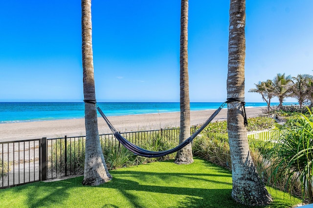 property view of water featuring fence and a view of the beach