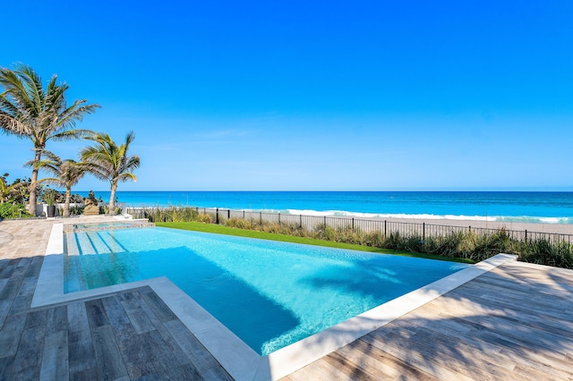 view of swimming pool with a fenced in pool, a patio area, and a water view