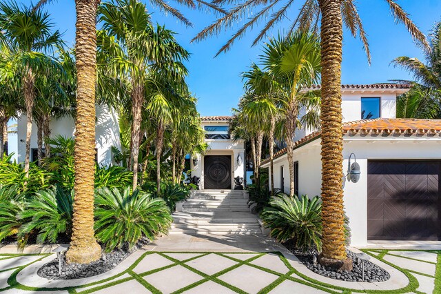 rear view of property with an outdoor pool, a patio, and stucco siding