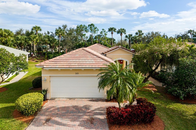 mediterranean / spanish house with a garage and a front lawn