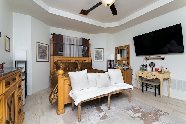 living room featuring ceiling fan and a tray ceiling