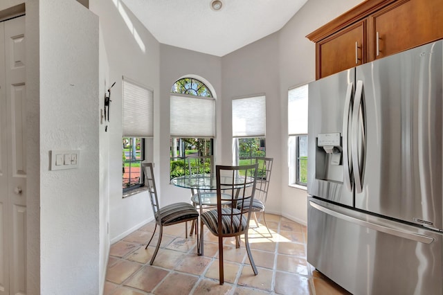 kitchen featuring a barn door, light tile patterned floors, and stainless steel fridge with ice dispenser