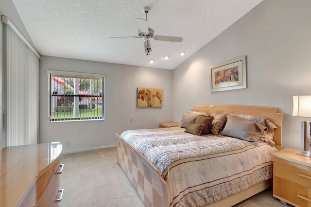 bedroom featuring lofted ceiling, ceiling fan, light colored carpet, and a textured ceiling