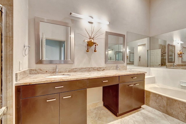 bathroom featuring vanity and a relaxing tiled tub