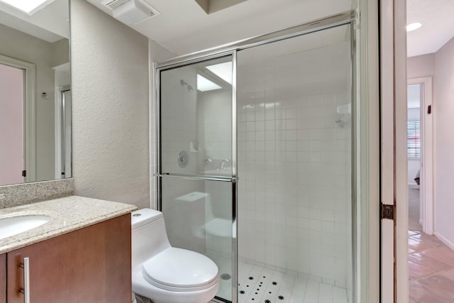 bathroom featuring vanity, walk in shower, and toilet