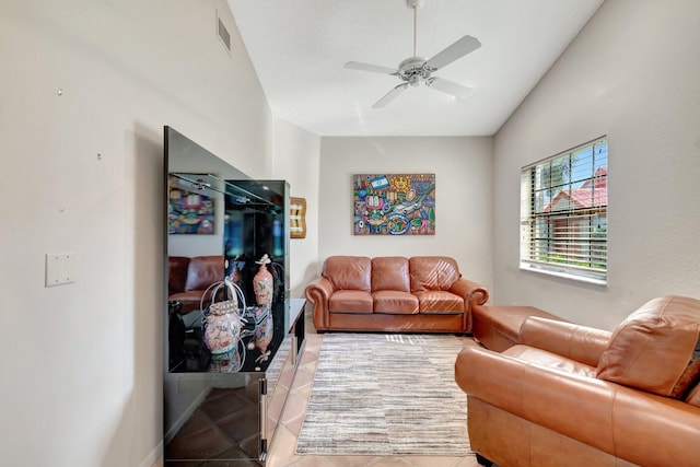 living room with lofted ceiling, light tile patterned floors, and ceiling fan