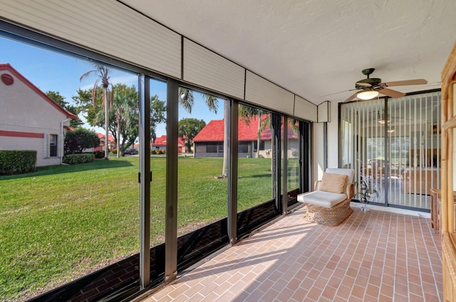 unfurnished sunroom featuring ceiling fan