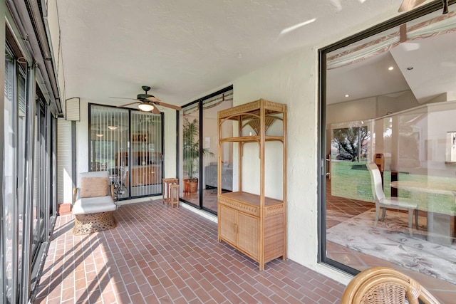 unfurnished sunroom with ceiling fan