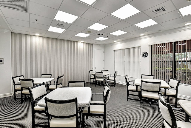 dining room featuring dark carpet and a paneled ceiling