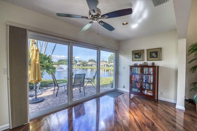 6938 Touchstone Cir, Palm Beach Gardens, FL 33418 - spare room with a water view, baseboards, wood finished floors, ceiling fan, and a textured ceiling