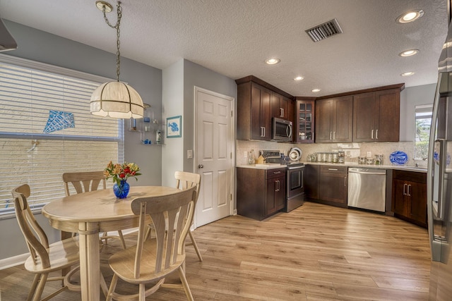 6938 Touchstone Cir, Palm Beach Gardens, FL 33418 - kitchen featuring appliances with stainless steel finishes, light countertops, light wood-style flooring, a textured ceiling, and recessed lighting