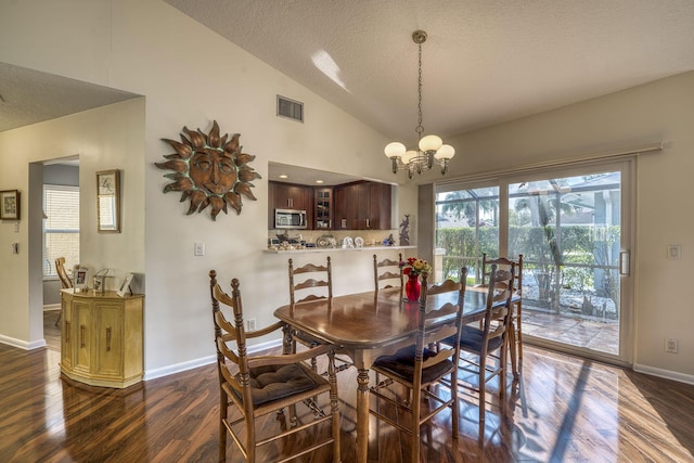 dining space with dark hardwood / wood-style flooring, high vaulted ceiling, a textured ceiling, and an inviting chandelier