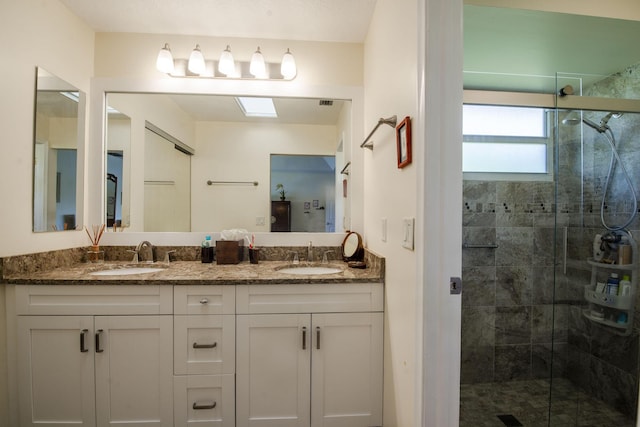 bathroom with vanity and a shower with door