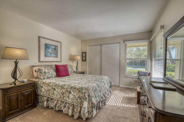 carpeted bedroom with a closet and a textured ceiling