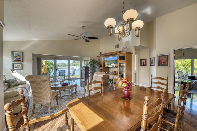 dining room featuring ceiling fan, dark hardwood / wood-style flooring, high vaulted ceiling, and a textured ceiling