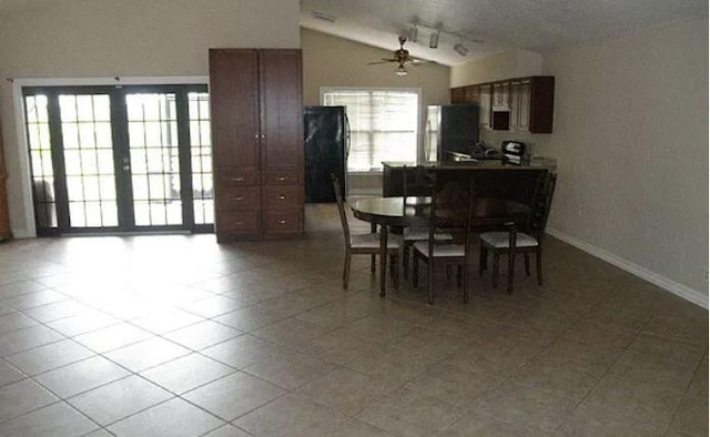 dining room with lofted ceiling, light tile patterned floors, and ceiling fan