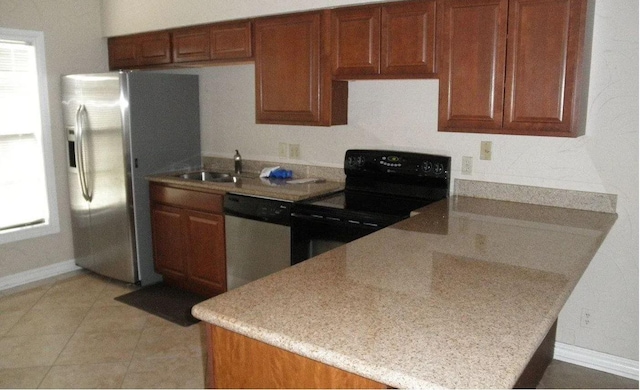 kitchen featuring sink, light tile patterned floors, appliances with stainless steel finishes, kitchen peninsula, and a healthy amount of sunlight