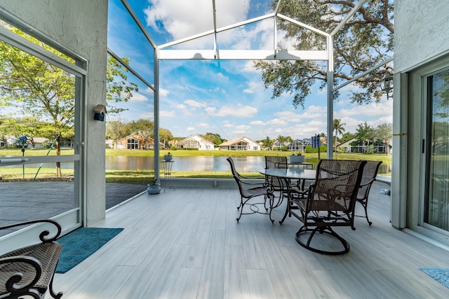 sunroom featuring a water view