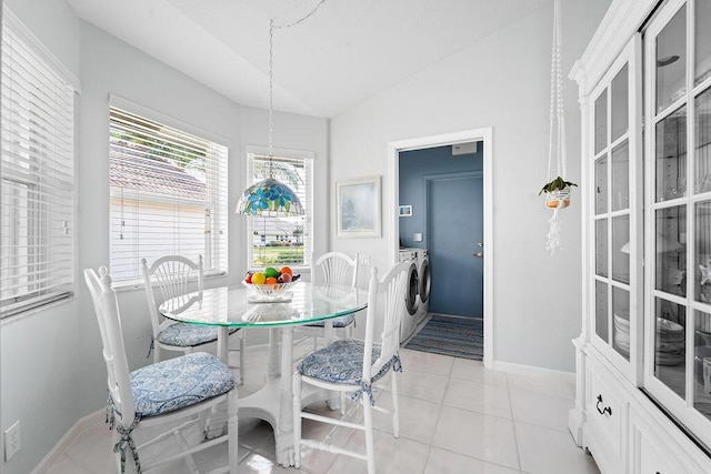 tiled dining room with lofted ceiling and independent washer and dryer