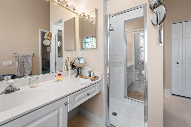 bathroom featuring vanity, tile patterned flooring, a shower with shower door, and toilet