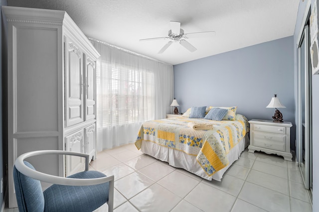 tiled bedroom with a textured ceiling and ceiling fan