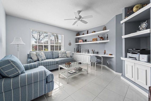 living room with ceiling fan, built in desk, a textured ceiling, and light tile patterned flooring