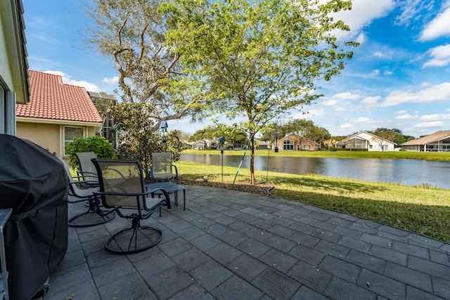 view of patio with area for grilling and a water view