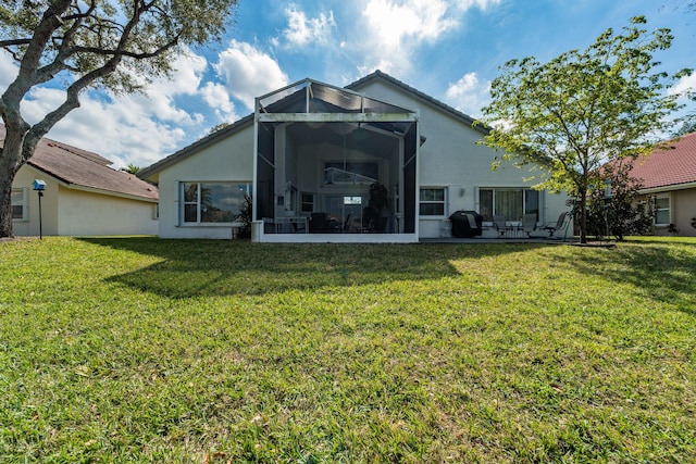 back of property featuring a patio area, glass enclosure, and a lawn