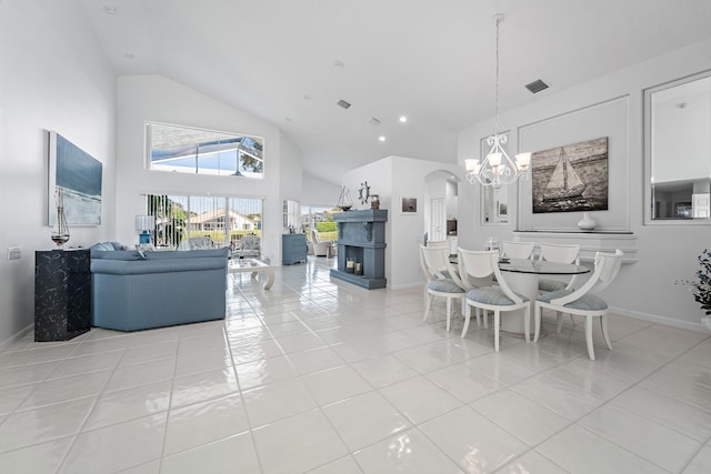 dining area with high vaulted ceiling, a chandelier, and light tile patterned flooring