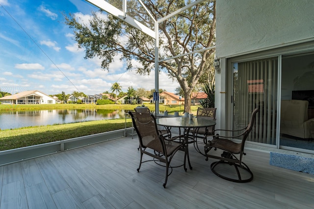 deck with a water view and a lawn