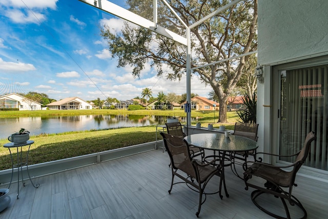 wooden terrace featuring a lawn and a water view