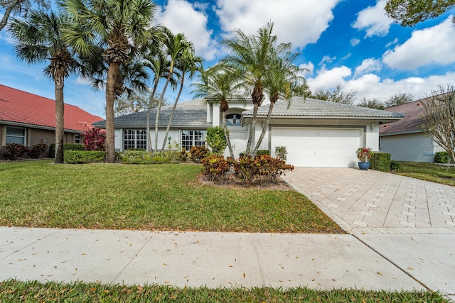 ranch-style home with a garage and a front lawn