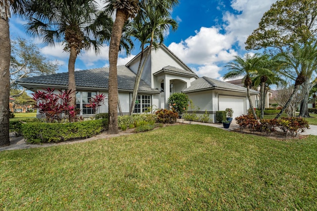 view of front of home with a garage and a front lawn