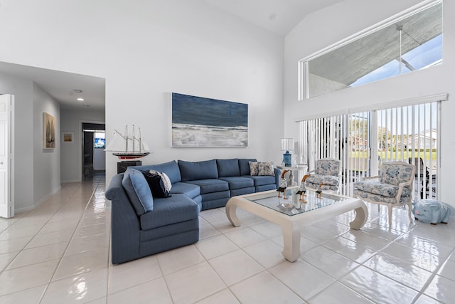 living room with light tile patterned flooring and high vaulted ceiling