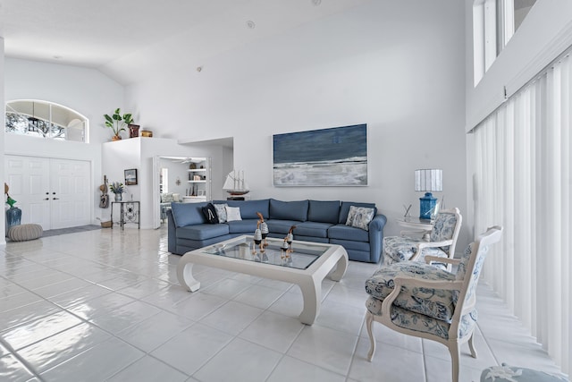 living room with high vaulted ceiling and light tile patterned flooring