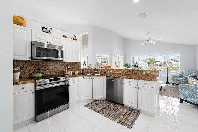 kitchen with white cabinetry, lofted ceiling, appliances with stainless steel finishes, and kitchen peninsula