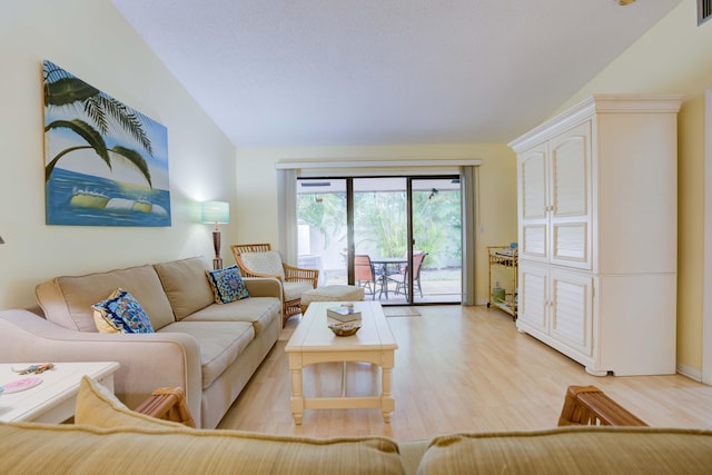 living room featuring vaulted ceiling and light hardwood / wood-style floors