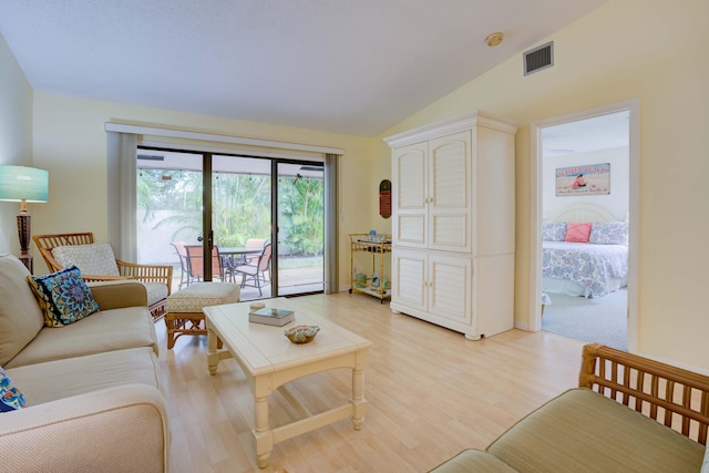 living room with light hardwood / wood-style floors and vaulted ceiling