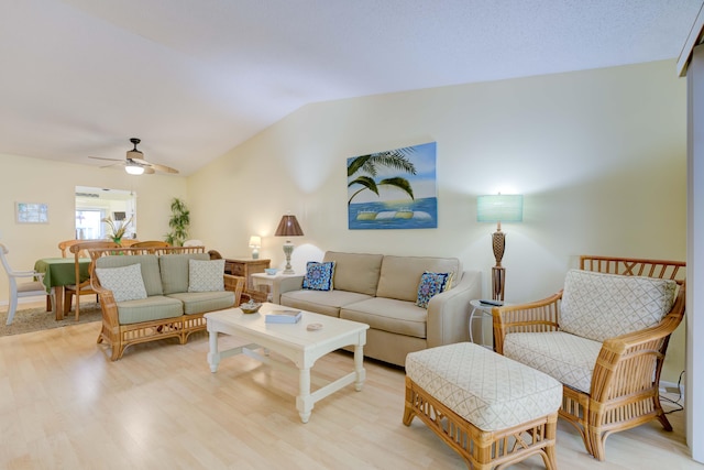 living room with lofted ceiling, ceiling fan, and light hardwood / wood-style flooring