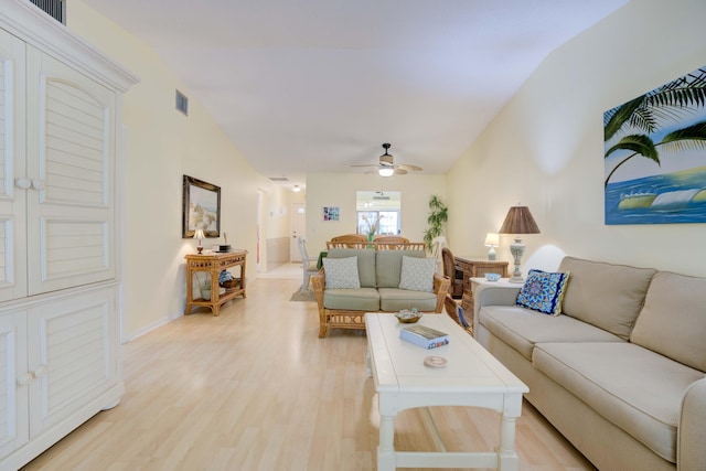 living room with vaulted ceiling, ceiling fan, and light wood-type flooring