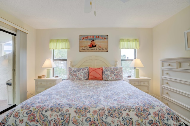 bedroom with multiple windows, ceiling fan, and a textured ceiling