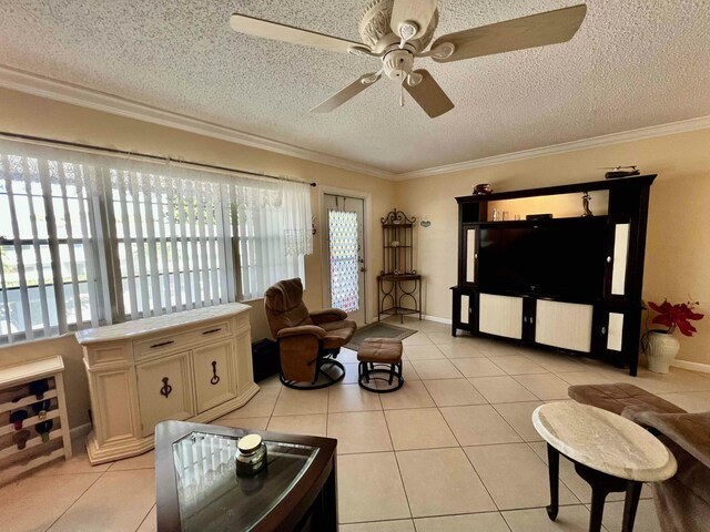 living room with ornamental molding, light tile patterned floors, ceiling fan, and a textured ceiling