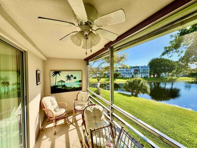 sunroom with a water view and ceiling fan