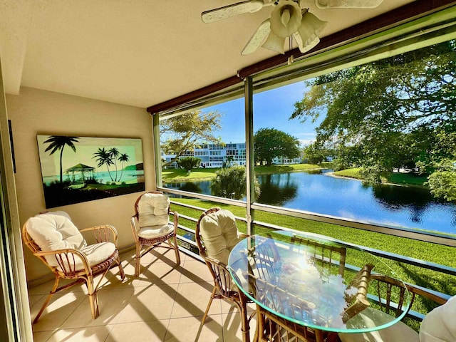 sunroom / solarium featuring a water view and ceiling fan