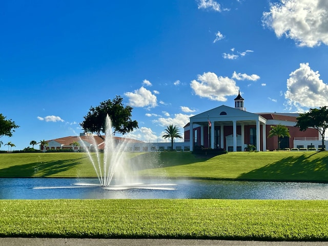 view of community with a water view and a lawn