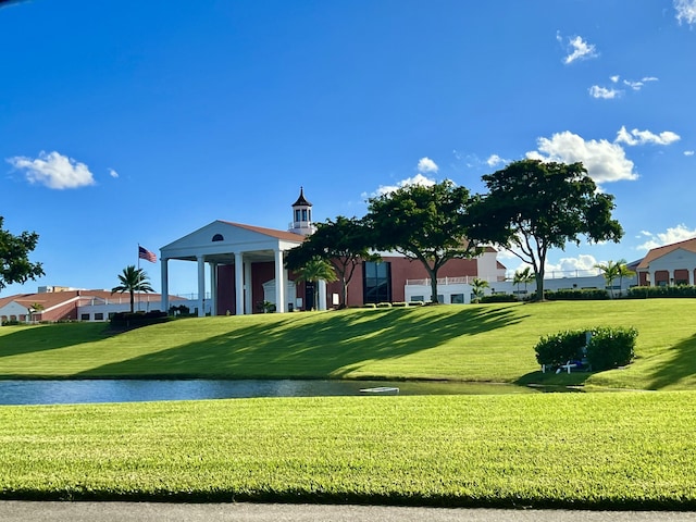 surrounding community featuring a lawn and a water view