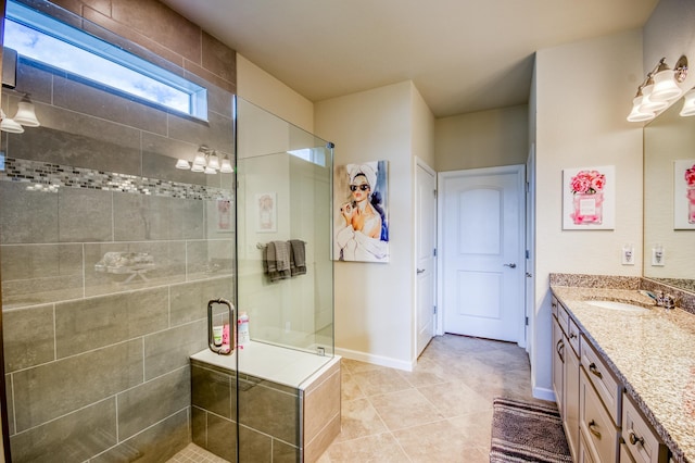 bathroom featuring a shower with door, vanity, and tile patterned flooring