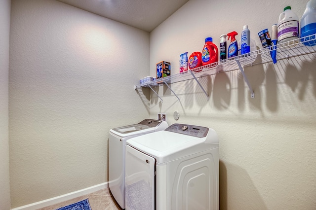 laundry room featuring washing machine and dryer and light tile patterned floors