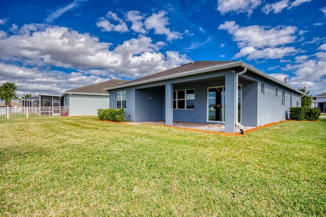 rear view of house with a patio and a yard